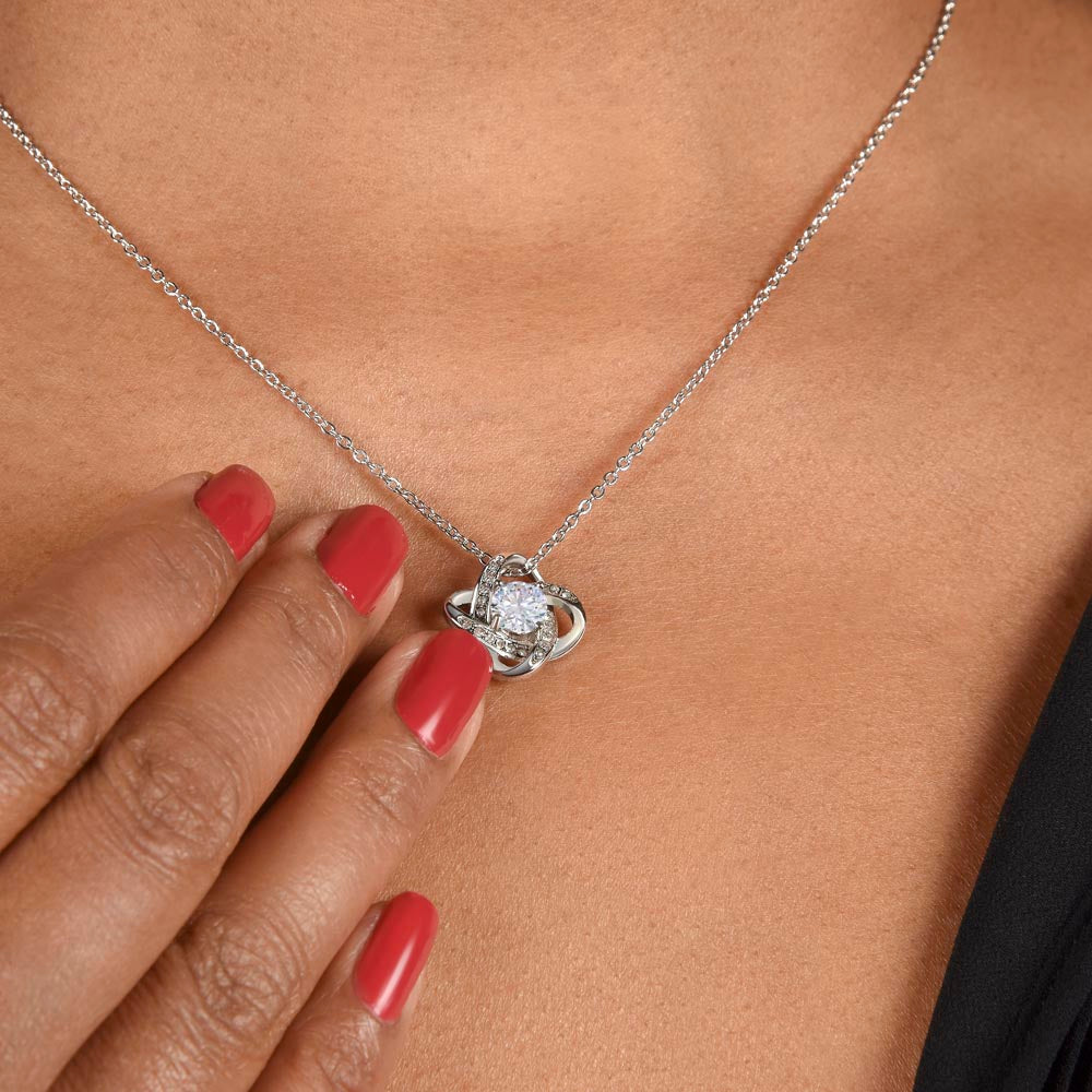 A woman wearing a I Squeezed This Pendant Love Knot Necklace - For Mom by ShineOn Fulfillment.
