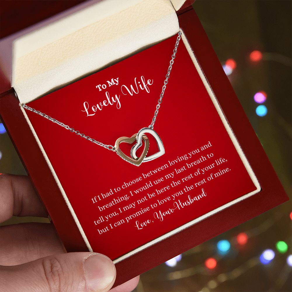 A person holding a ShineOn Fulfillment gift box with a Love You The Rest of Mine Interlocking Hearts Necklace - Gift for Wife from Husband.