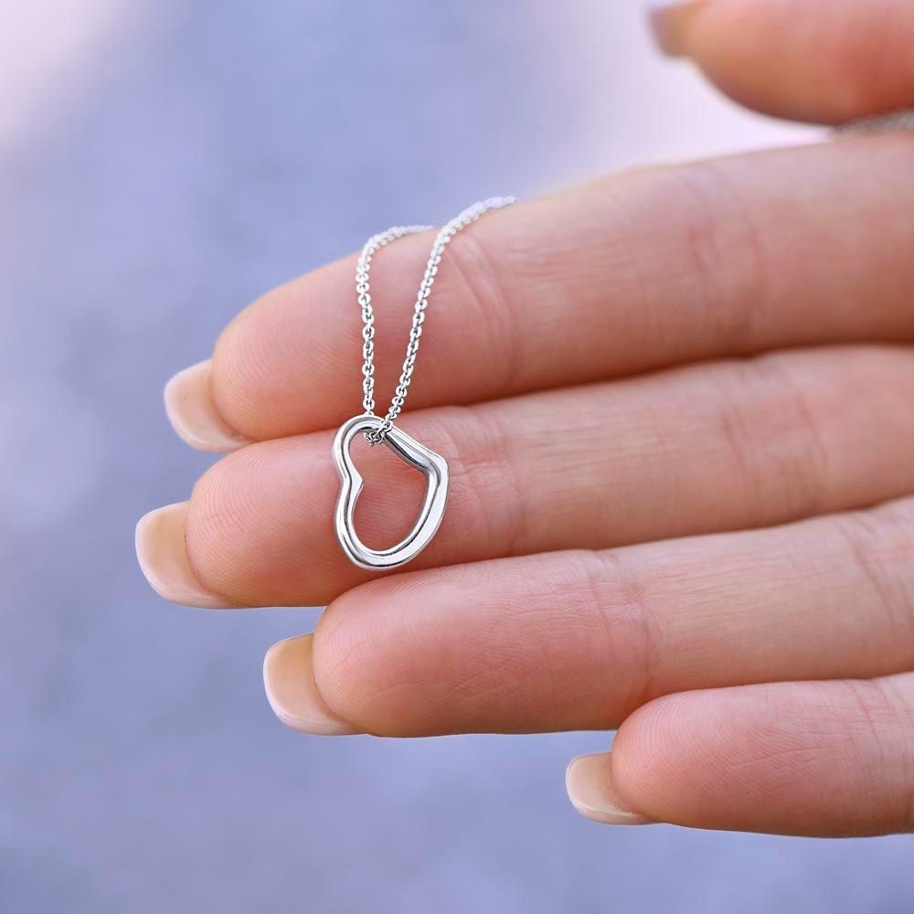 A person's hand holding a Silver Always Keep Me In Your Heart Delicate Heart Necklace- Gift for Daughter from Mom, from the brand ShineOn Fulfillment.