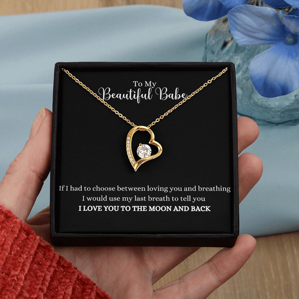 A woman holding a Love you to the moon and back Forever Love Necklace - For Soulmate or Wife in a box.